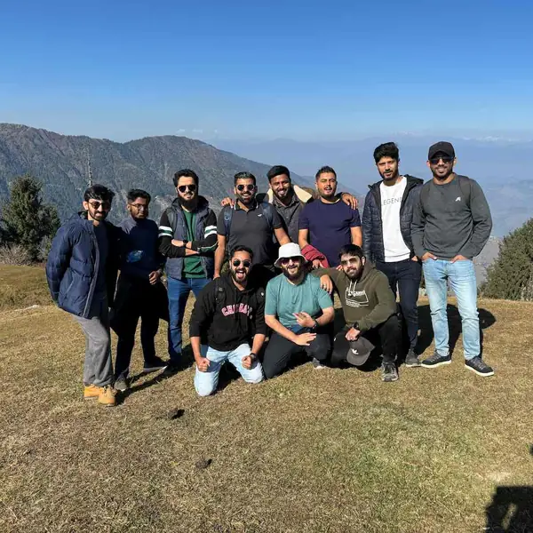 The Next Order team on a hilltop during a team trip, with mountains behind them.
