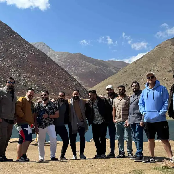 The team standing together beside a mountain lake on a team trip.